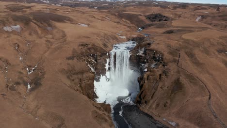 After-winter-scene-at-Skogafoss-waterfall-in-Iceland-highlands,-aerial