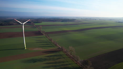 Luftaufnahme-Der-Rotierenden-Rotorblätter-Einer-Riesigen-Windkraftanlage-In-Einer-Weiten-Ländlichen-Landschaft