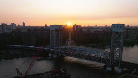 Zug-Auf-Der-Park-Avenue-Bridge,-Offenbarender-Sonnenuntergang-über-Harlem,-New-York---Aufsteigend,-Luftaufnahme
