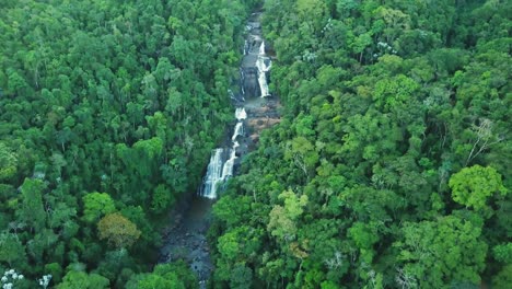 Beautiful-tilting-aerial-shot-of-huge-waterfall-in-green-jungle,-Brazil-Minas-Gerais