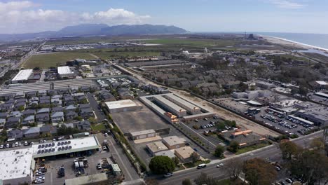 High-panning-aerial-shot-of-an-industrial-park-in-Port-Hueneme-with-the-Santa-Monica-Mountains-in-the-background