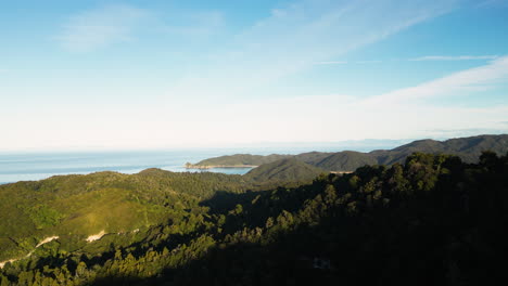 Aerial-flying-over-densely-forested-hills-towards-Totaranui-Beach-in-the-Abel-Tasman-National-Park,-South-Island,-New-Zealand