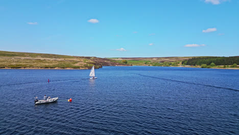 Winscar-reservoir-in-Yorkshire-serves-as-the-backdrop-for-a-weekend-sporting-event,-where-sailing-enthusiasts-indulge-in-a-thrilling-boat-race-with-their-small-one-man-boats