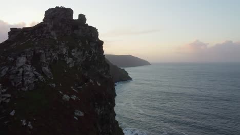 Golden-Hour-Sunset-View-Along-Coastline-with-Calm-Sea-and-Mountain-Top---Aerial-Drone-Footage