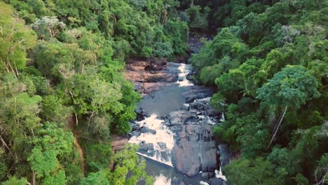 Breathtaking-aerial-establishing-shot-of-river-and-waterfall-in-huge-green-rainforest,-Minas-Gerais-Brazil
