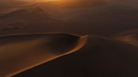 Luftaufnahme-über-Staubige-Dünen,-Dramatischer,-Lebendiger-Sonnenuntergang-In-Namibia,-Afrika