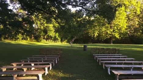 Outdoor-wedding-location-in-park-with-wooden-chairs-and-benches