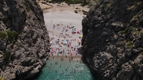 View-of-Tourists-sunbathing-on-beach-at-Torrent-de-Pareis,-Mallorca,-Spain