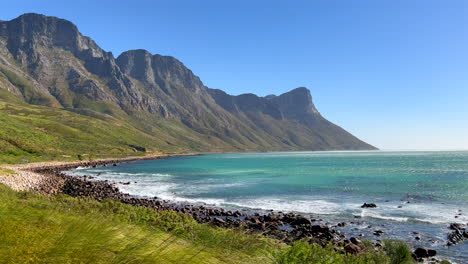 Koeel-Bay-Dappat-Se-Gat-cinematic-windy-grass-surf-waves-crashing-stunning-Kogel-Bay-Beach-Cape-Town-South-Africa-coastline-aqua-deep-blue-water-Gordon's-Bay-Garden-Route-stunning-pan-left