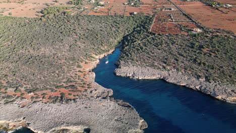 Asombrosa-Vista-De-Un-Pequeño-Bote-Navegando-En-Medio-De-La-Bahía-Entre-Sa-Coma-Y-Porto-Cristo-En-Mallorca,-España