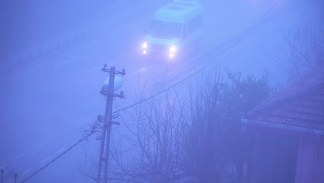 Tour-buses-and-cars-drive-along-hazy-purple-road-with-utility-poles-in-front