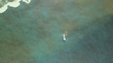 Von-Oben-Nach-Unten-Drohnen-Luftaufnahme-Eines-Kleinen-Fischerbootes-Und-Netzes-Im-Grünen-Meerwasser-An-Der-Küste-Von-Iquique,-Chile,-Hoher-Winkel