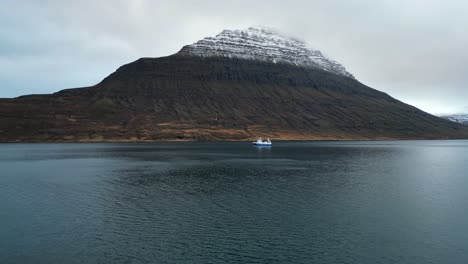Barco-Navegando-En-El-Fiordo-Islandés,-Vista-Aérea-De-Establecimiento