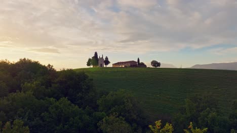 Aerial-of-the-Chapel-of-the-Madonna-di-Vitaleta-at-sunrise,-Province-of-Siena,-Italy