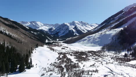 Bluebird-Sonniger-Tag-Frühling-Winter-Colorado-Wunderschöne-Aussicht-Auf-Die-Berge-Und-Friedlicher-Bach-Ashcroft-Maroon-Bells-Aspen-Colorado-Ikonische-Landschaft-Luftaufwärtsbewegung