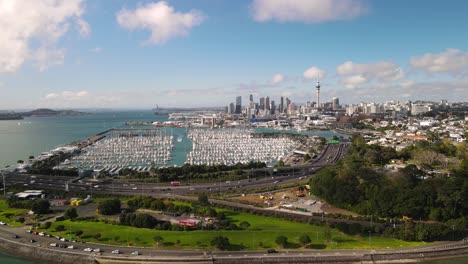 Birds-eye-view-of-the-biggest-New-Zealand-metropolitan-city,-marine-harbour-with-boats-and-usuall-traffic