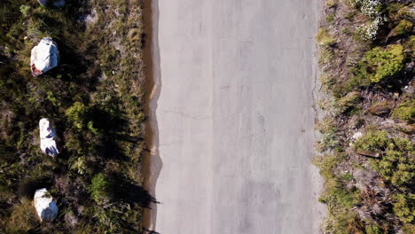 MTB-cyclist-cycling-with-perfect-90-degree-shadow-from-sun,-aerial-top-down
