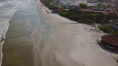 Tilting-aerial-shot-of-ocean-beach-in-summer-time-with-beautifull-sea-and-clouds