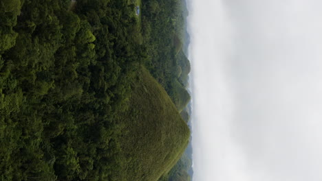 Vertical-panning-shot-of-the-Chocolate-Hills-and-forest-valley-in-Bohol,-Thailand