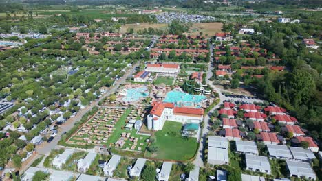 Luxury-campsite-and-swimming-pool-at-Lake-Garda-Italy-on-sunny-day,-aerial-orbit