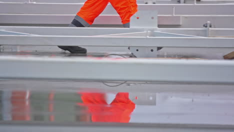 Slow-motion-shot-of-construction-workers-walking-on-a-wet-construction-site-in-fluorescent-clothing