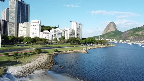 Buildings,-beach-and-Sugar-loaf,-Pao-de-Acucar,-on-the-background---drone-shot-at-Rio-de-janeiro