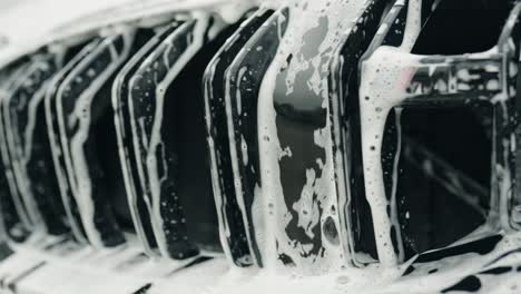 soap-and-water-falls-between-twin-kidney-grille-of-a-car-forming-an-interesting-little-cascade-with-reflections