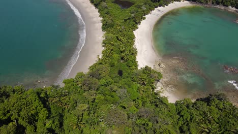Drone-shot-over-flying-Manuel-Antonio-beach-and-National-Park,-Costa-Rica