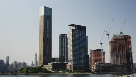 In-Der-Skyline-Von-Manhattan-Sind-Neue-Wohngebäude-Im-Bau,-Die-In-Orangefarbene-Tücher-Gehüllt-Sind
