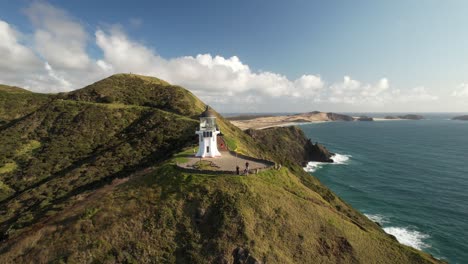 Beautifully-located-Cape-Reinga-Lighthouse-with-lookout-and-picturesque-New-Zealand-coastal---aerial-drone