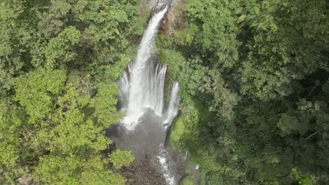 Ascending-jungle-aerial-tilts-down-Tiu-Kelep-waterfall-in-Lombok,-IDN