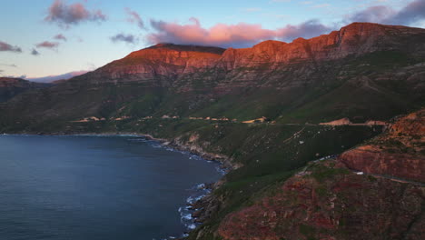 Chapman-Peak-drive-South-Africa-sunset-drive-aerial-cinematic-drone-Hout-Bay-marina-Cape-Town-Fish-Hoek-Good-Hope-Table-Mountain-rugged-coast-aqua-deep-blue-water-green-summer-to-the-left-movement