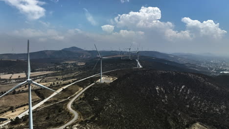 Aerial-view-following-a-line-of-wind-power-generators-in-Esperanza,-Puebla,-Mexico