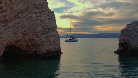 Yacht-anchored-in-the-Mediterranean-sea-next-to-caves-and-rocks