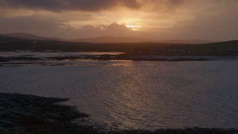Golden-hour-shot-of-a-sunset-obscured-by-passing-clouds-over-the-island-of-North-Uist