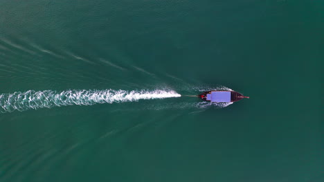Motor-long-tail-boat-cruising-in-sea-waters-with-Kelvin-wake-behind