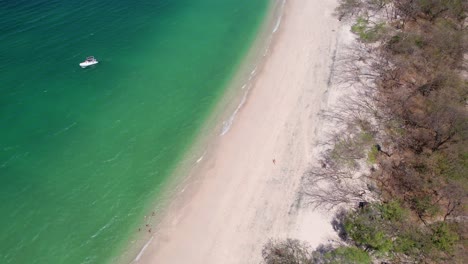 Aerial-drone-panning-shot-over-a-tranquil-clear-ocean-next-to-Playa-Conchal