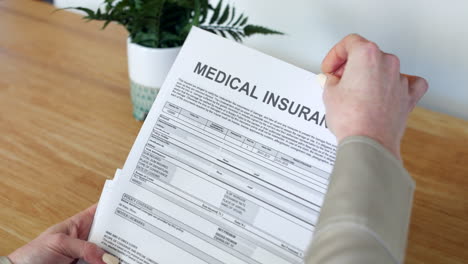 A-woman-opening-a-medical-Insurance-Document-letter-outlining-her-policy-and-cover-details