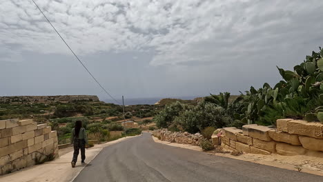 Woman-walking-along-a-countryside-road-in-Malta