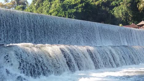 Waterfalls-in-Slow-Motion,-Long-Cascade-Flows-into-a-River,-Bali-Indonesia,-Klungkung,-Tirai-Air-Terjun-Tukad-Unda,-White-Water