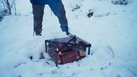 Eine-Person-Grillt-Im-Winter-Draußen-Mit-Würstchen-über-Feuerholz
