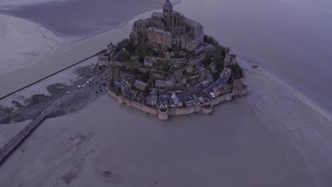Drone-flight-over-famous-Mont-Saint-Michel-at-overcast-day,-aerial