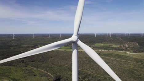 Close-up-backward-aerial,-establish-green-energy-producing-wind-mill-in-Portugal