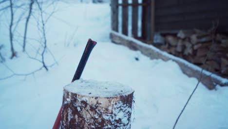 Holzbaumstumpf-Mit-Person,-Die-Im-Winter-Holzstämme-Schneidet
