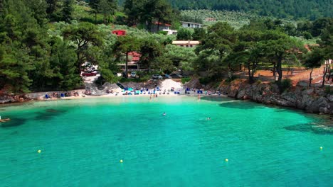 Circular-Drone-View-Of-Glifoneri-Beach,-With-Crystal-Clear-Water-And-Surrounded-By-Lush-Green-Vegetation,-Thassos-Island,-Greece,-Europe