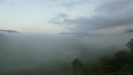 Flying-Over-Tropical-Forest-Mountains-Enveloping-Foggy-Morning-Clouds