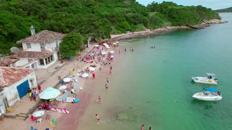 Aerial-establishing-orbit-of-Azeda-beach-full-of-people-enjoying-the-shore-and-playing,-Búzios,-Brazil