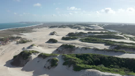 AERIAL---Beautiful-sandy-dunes-on-Genipabu-beach,-Brazil,-lowering-shot