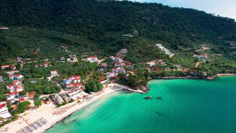 Drone-Camera-Slowly-Tilting-Down-To-Reveal-The-Beautiful-Golden-Beach-With-Turquoise-Water-And-Lush-Vegetation,-Thassos-Island,-Greece,-Europe