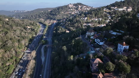 Highway-road-and-railway-tracks-lead-through-living-district-and-hilly-terrain-in-Spain